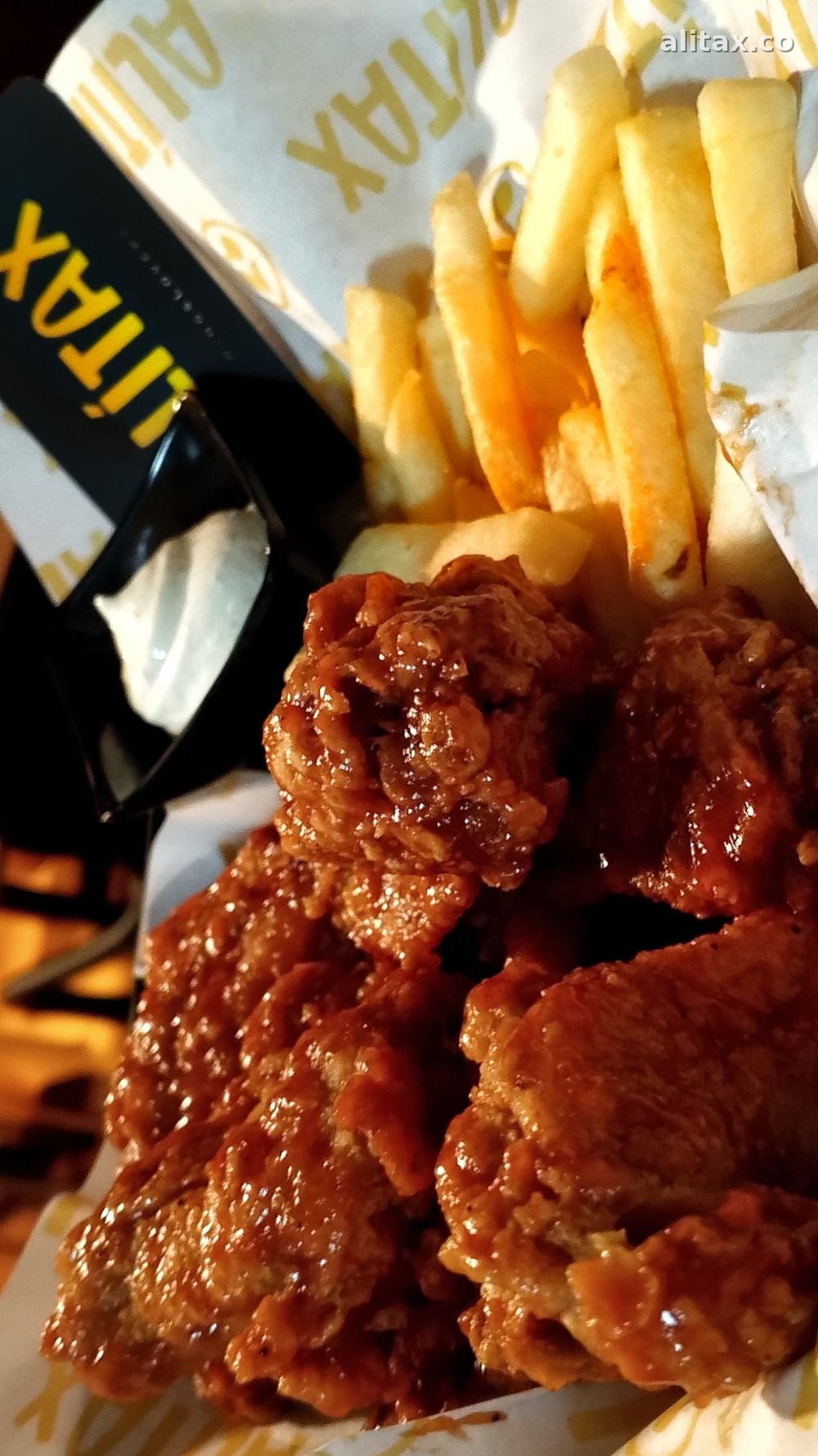 Alitas bañadas en salsa con papitas