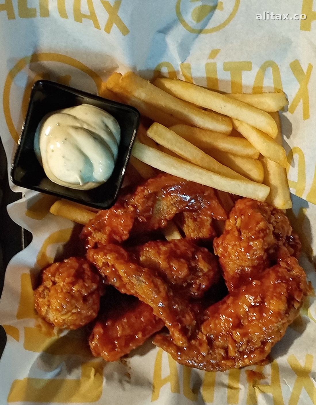 Alitas con salsa y papitas